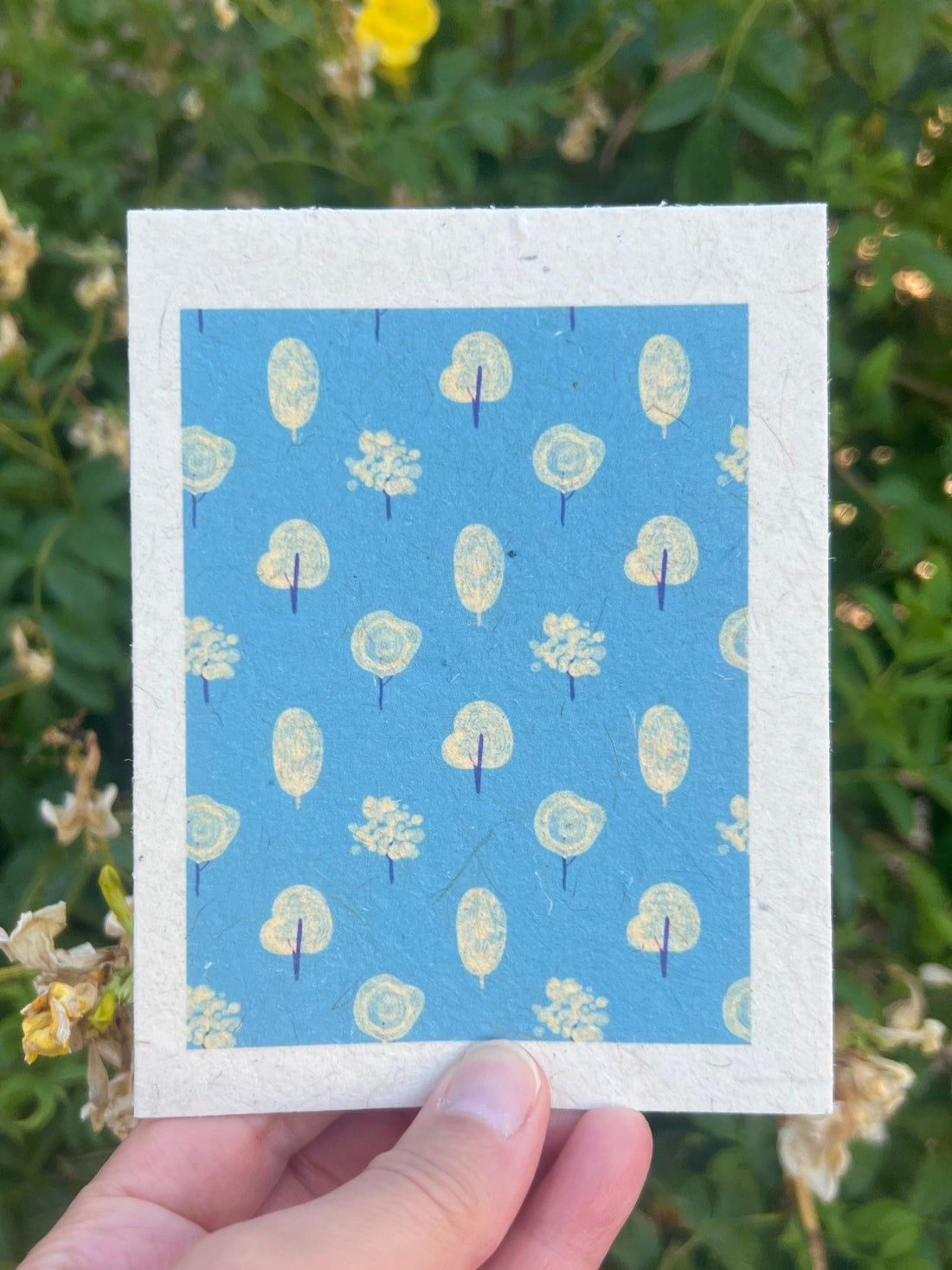 plantable card with sky blue background and cream trees winter themed